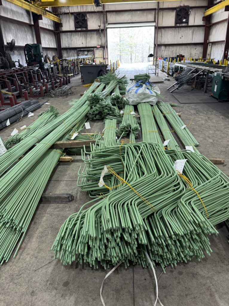 Epoxy-coated rebar bundles prepared for jobsite delivery inside fabrication facility